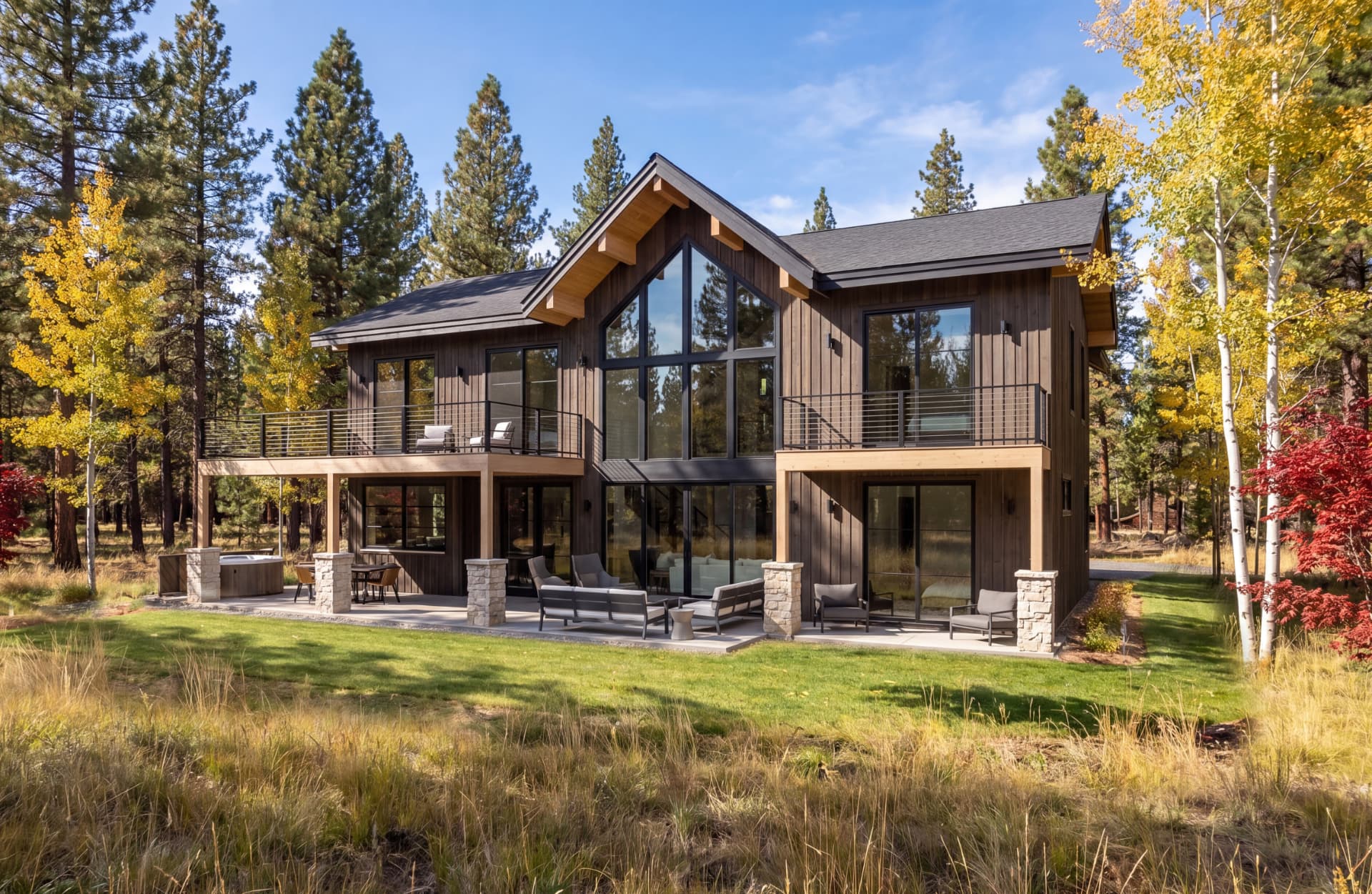 Starwater Snoqualmie Pass cabin design with gabled roof and tall glass walls among autumn aspen and pine