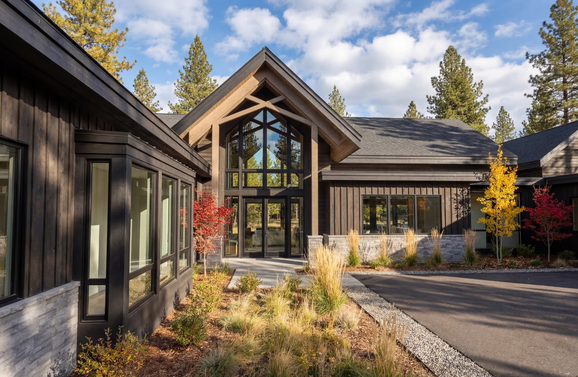 Suncadia architect-designed entry courtyard with timber truss and dark siding at Tumble Creek